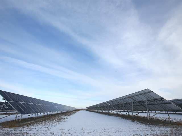 Solar panels on a snow covered field.
