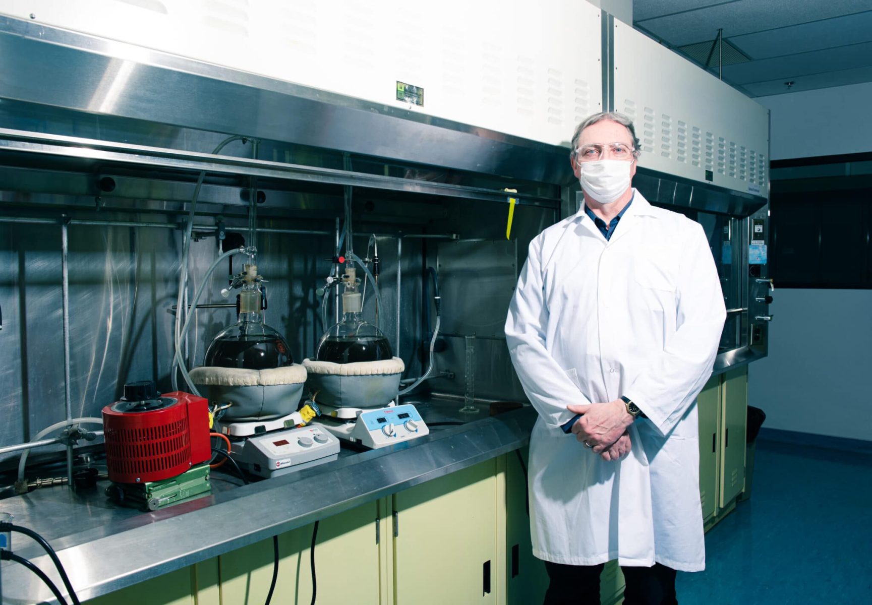A man in a lab coat standing in front of equipment.
