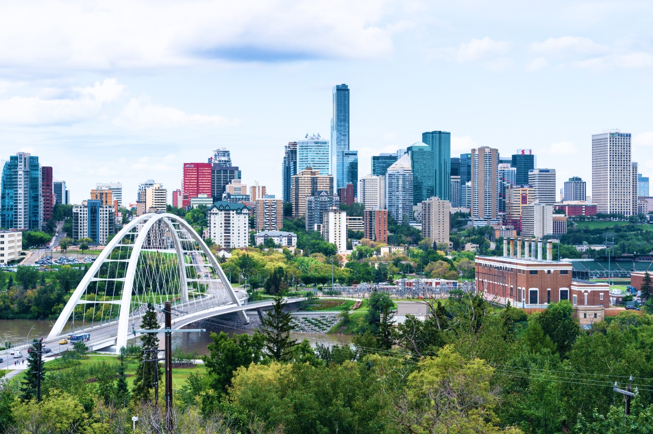 The skyline of edmonton with a bridge over a river.