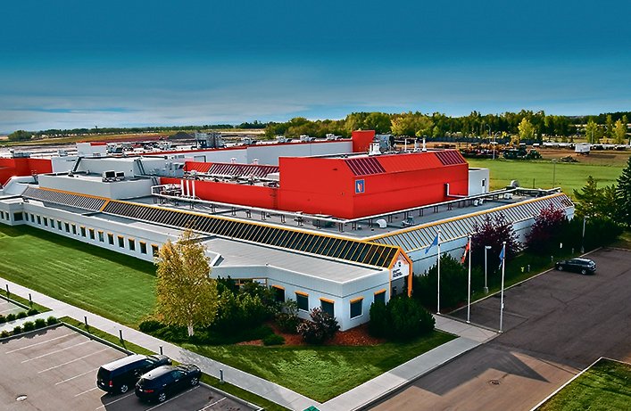 An aerial view of a large building with a red roof.