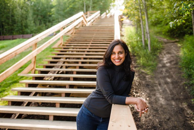 A woman leaning on a wooden stairway.