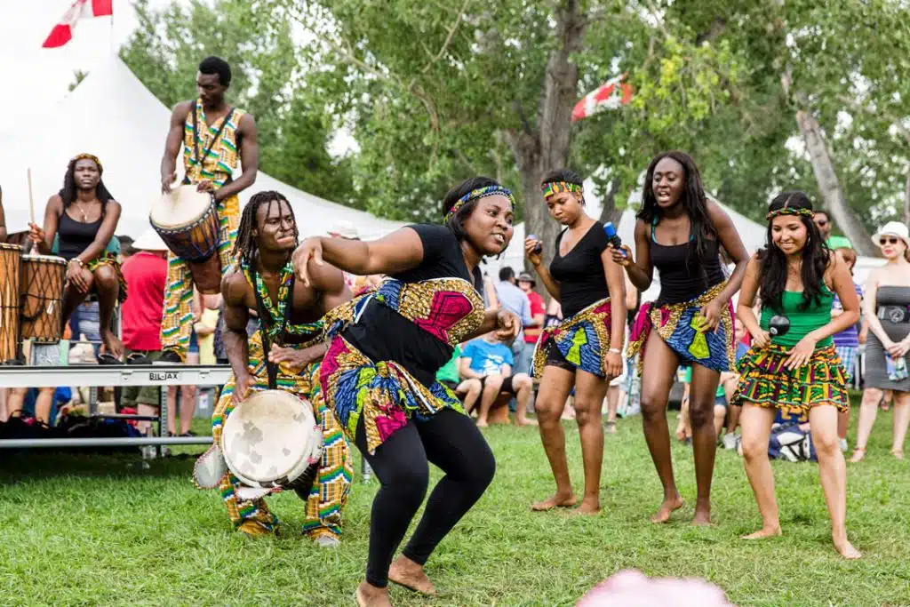 A group of people dancing in front of a tent.