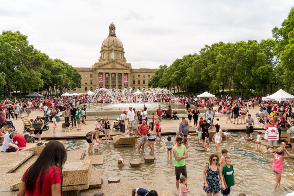 Edmonton's city square is crowded with people and fountains.