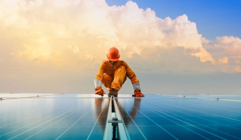 A worker is working on a solar panel.