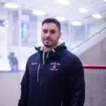 A man standing in front of a hockey net.