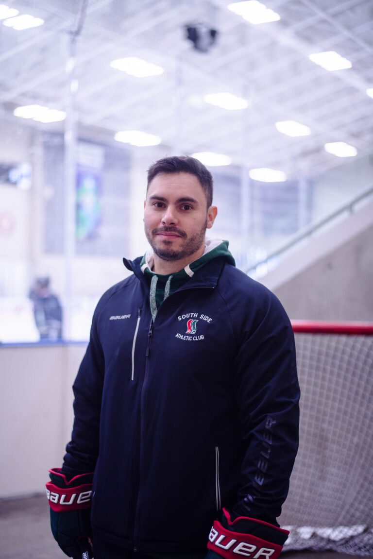 A man standing in front of a hockey net.
