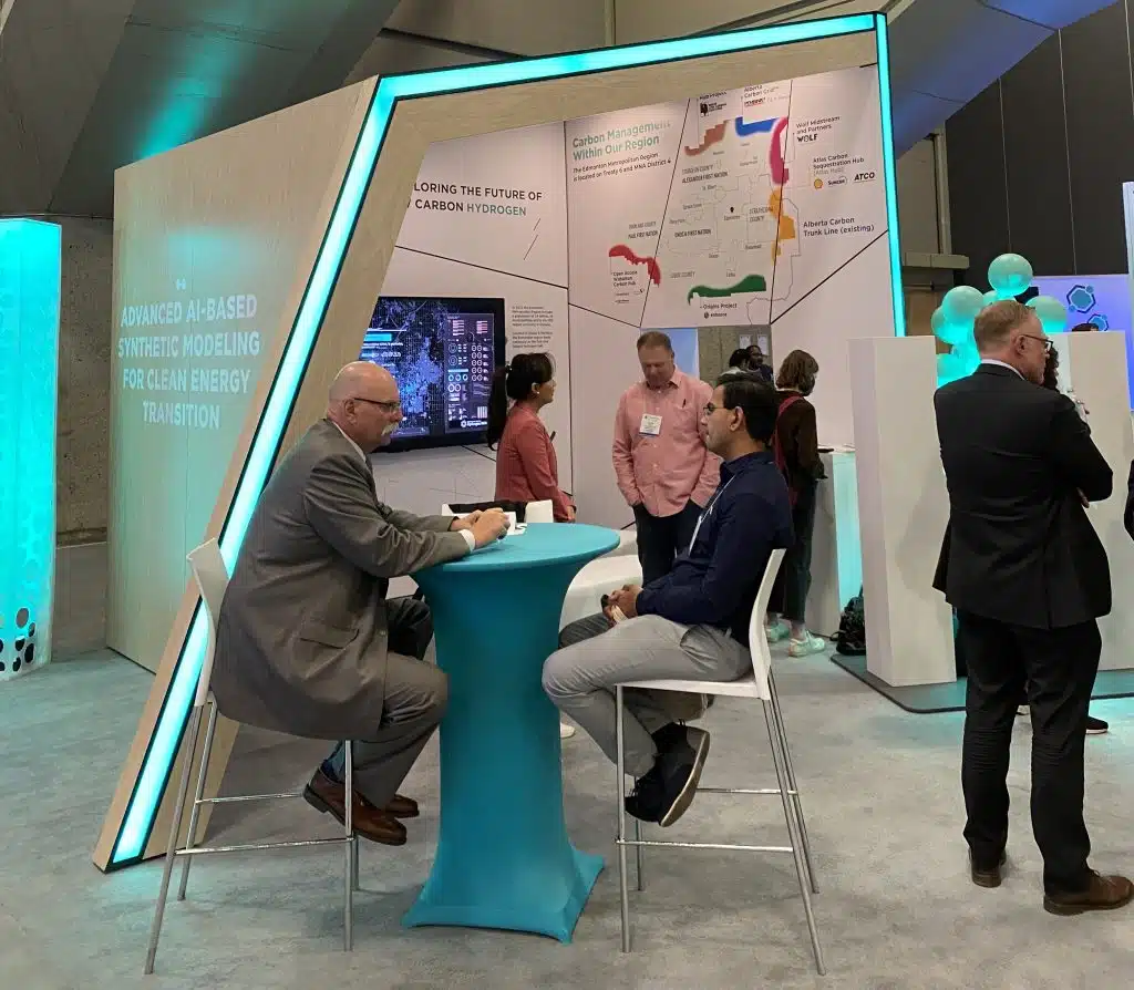 A group of people standing around a booth at a trade show.