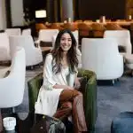 Manisha Arora sitting on a chair in a lobby.