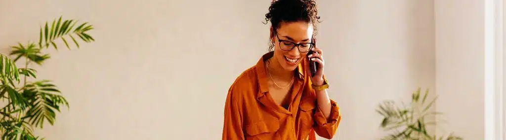 A woman talking on a cell phone in an office.