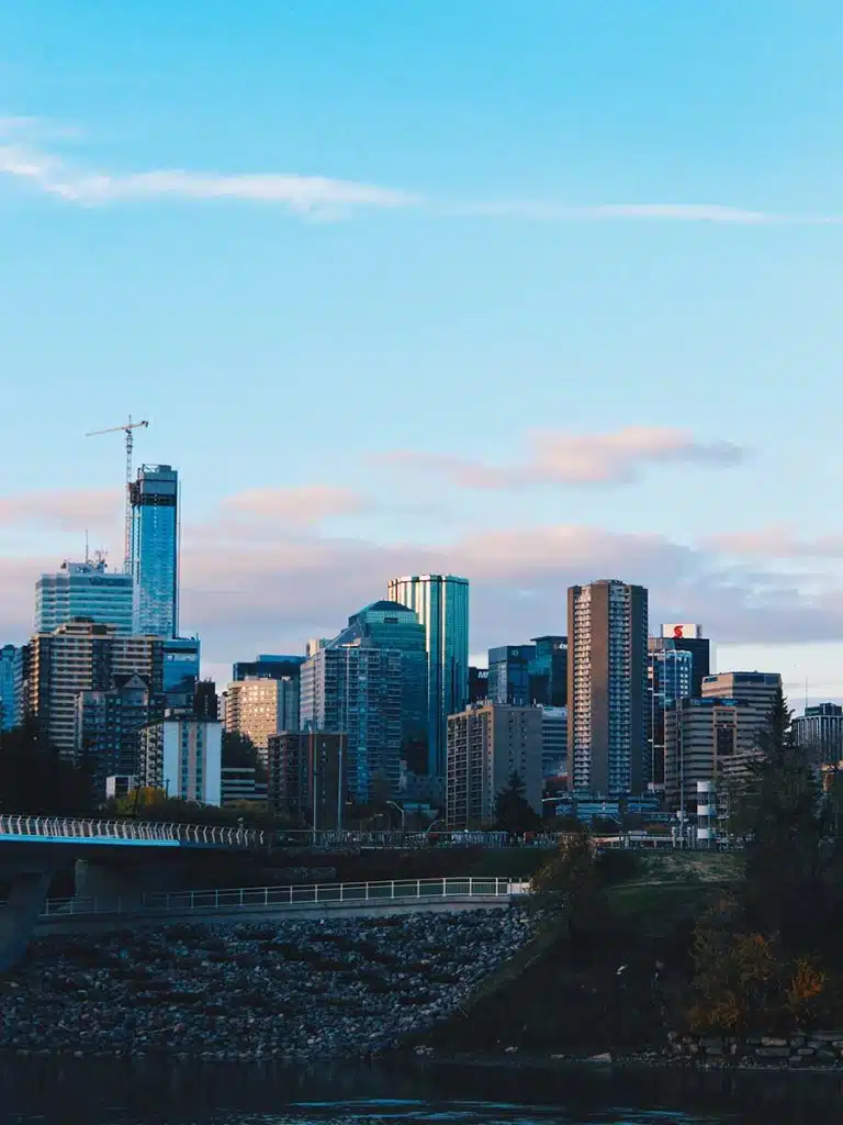 A city skyline with a bridge over a body of water.