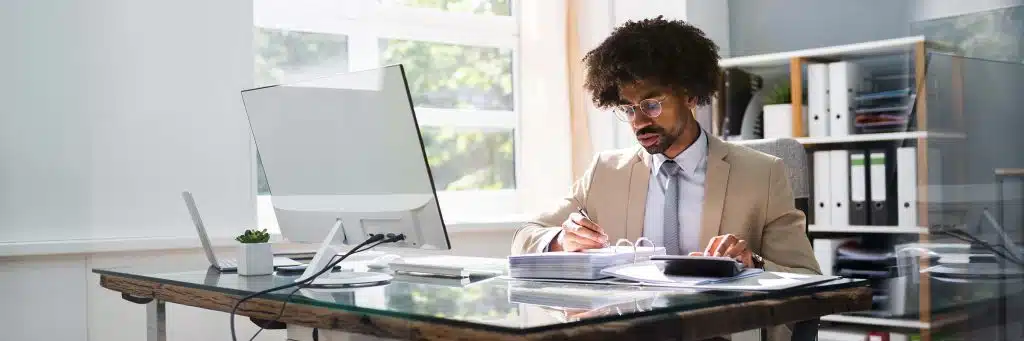 A man with afro hair sitting at a desk.