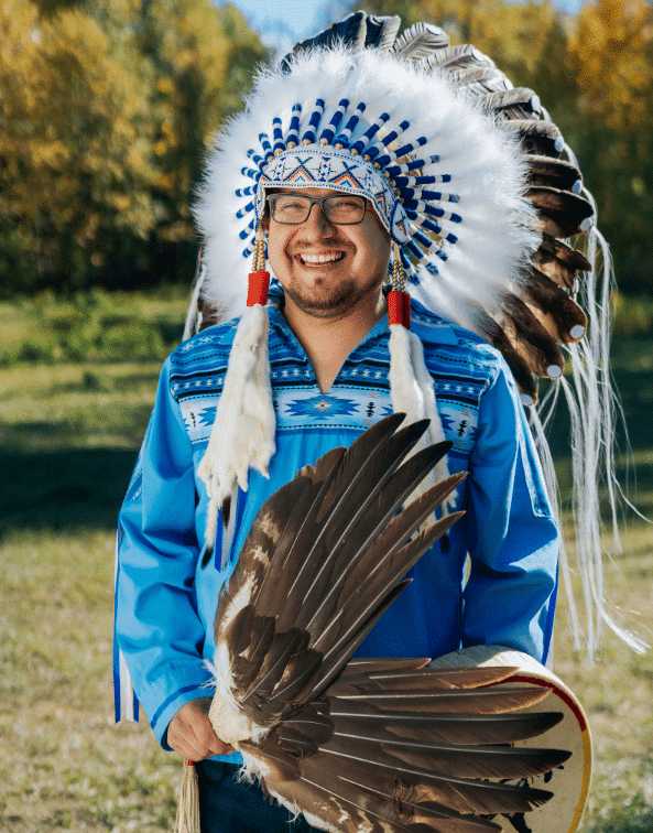 A man wearing a blue and white feathered headdress.