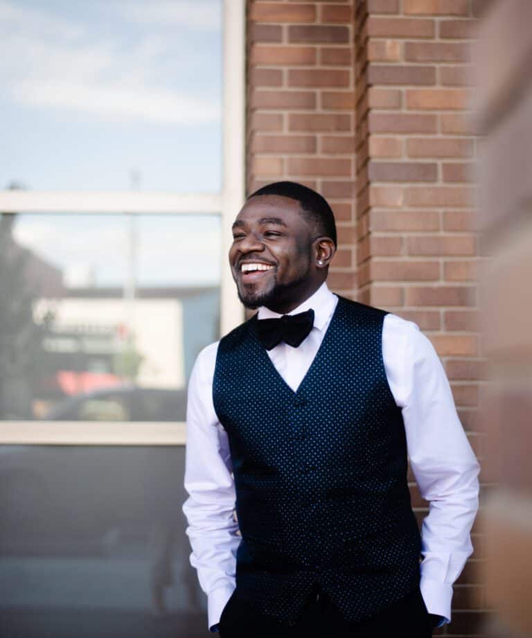 A black man wearing a vest and bow tie.