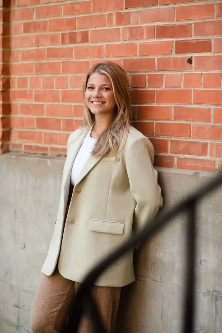 A woman leaning against a brick wall.