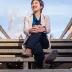 A woman sitting on a set of wooden stairs.