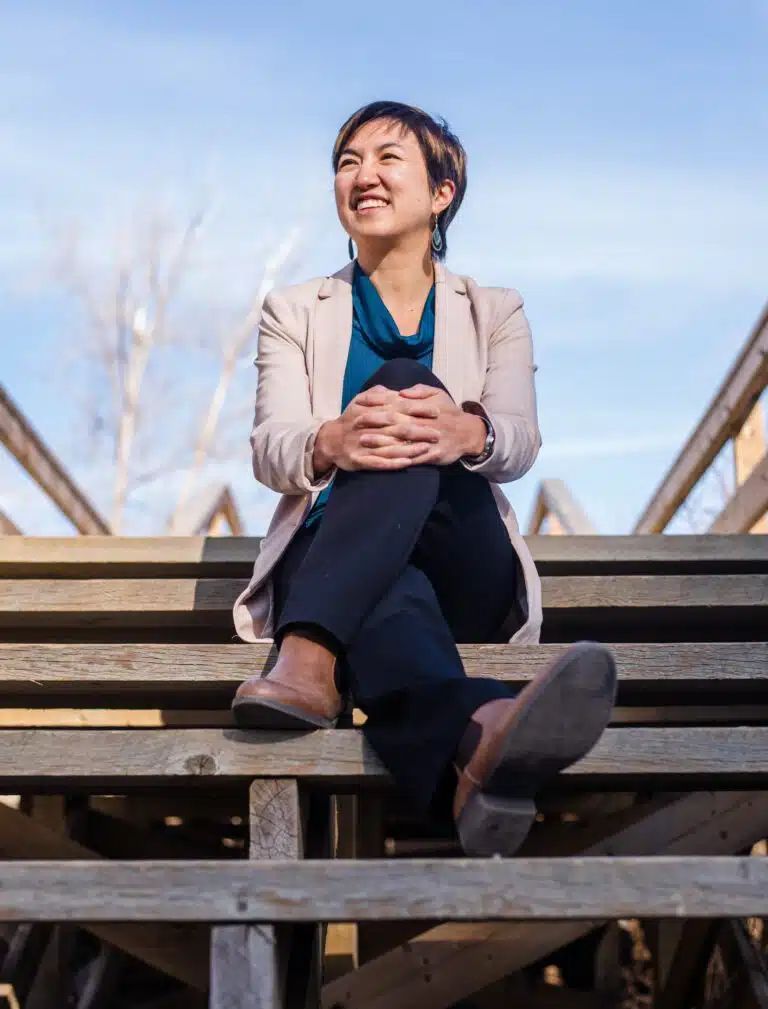 A woman sitting on a set of wooden stairs.