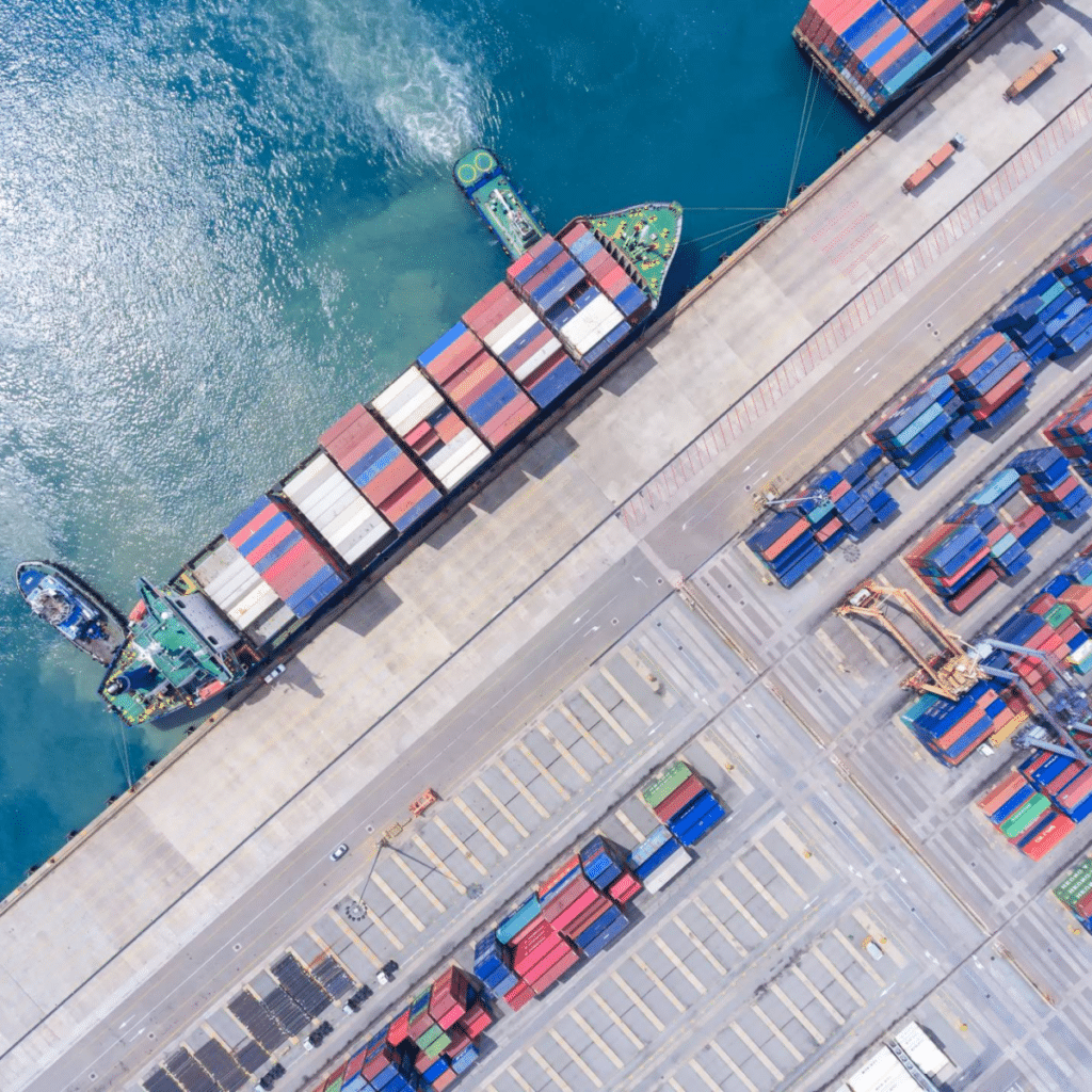 An aerial view of a container ship docked at a port.